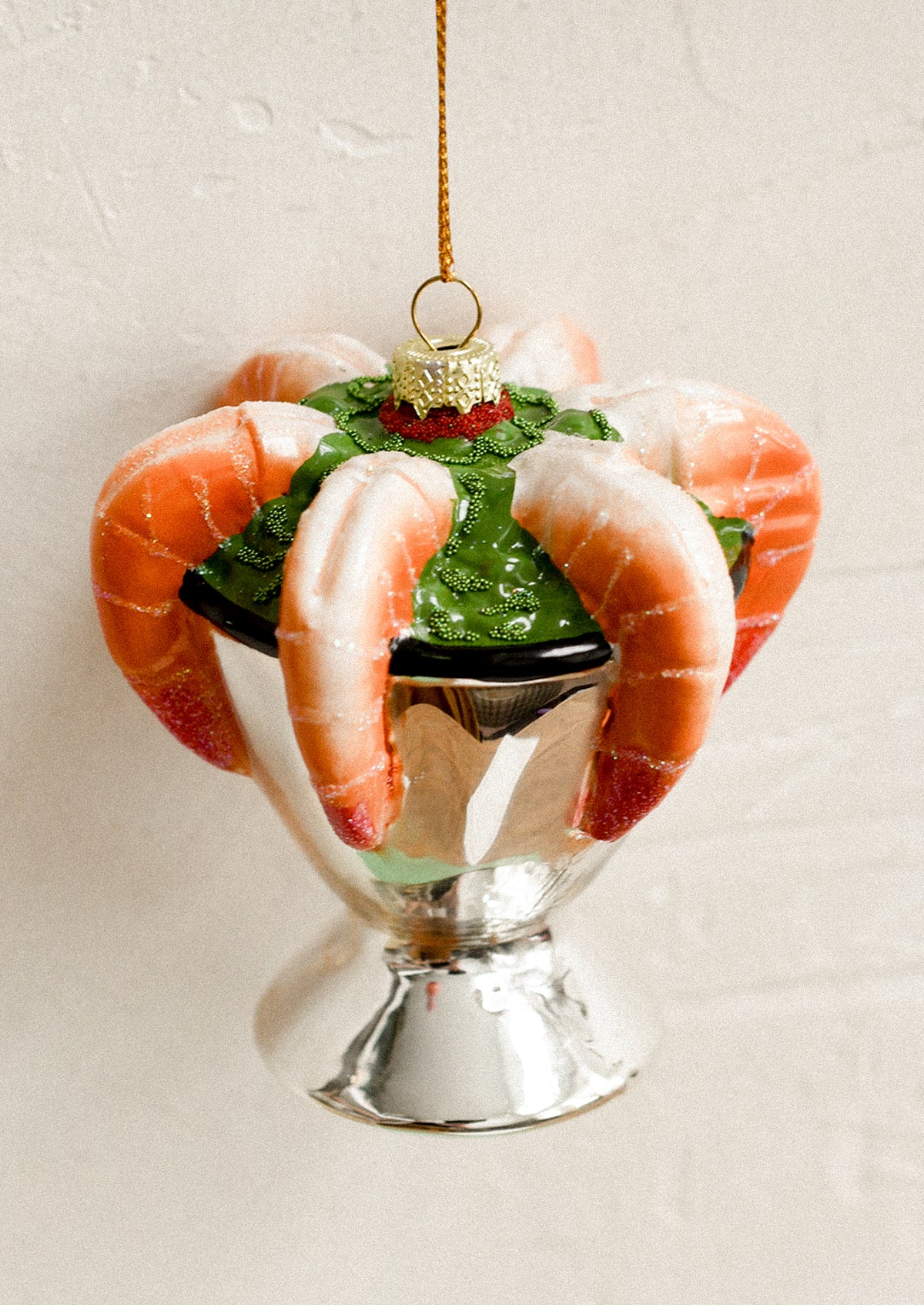 A glass ornament depicting a silver bowl of shrimp cocktail.
