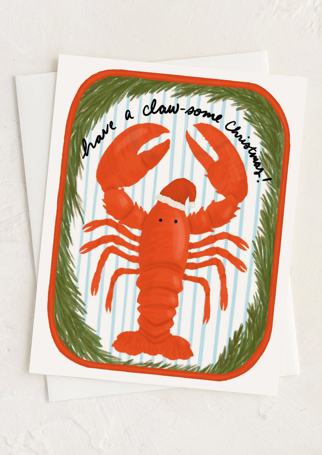 A greeting card with illustration of a lobster wearing santa hat, text reads "Have a claw-some Christmas".