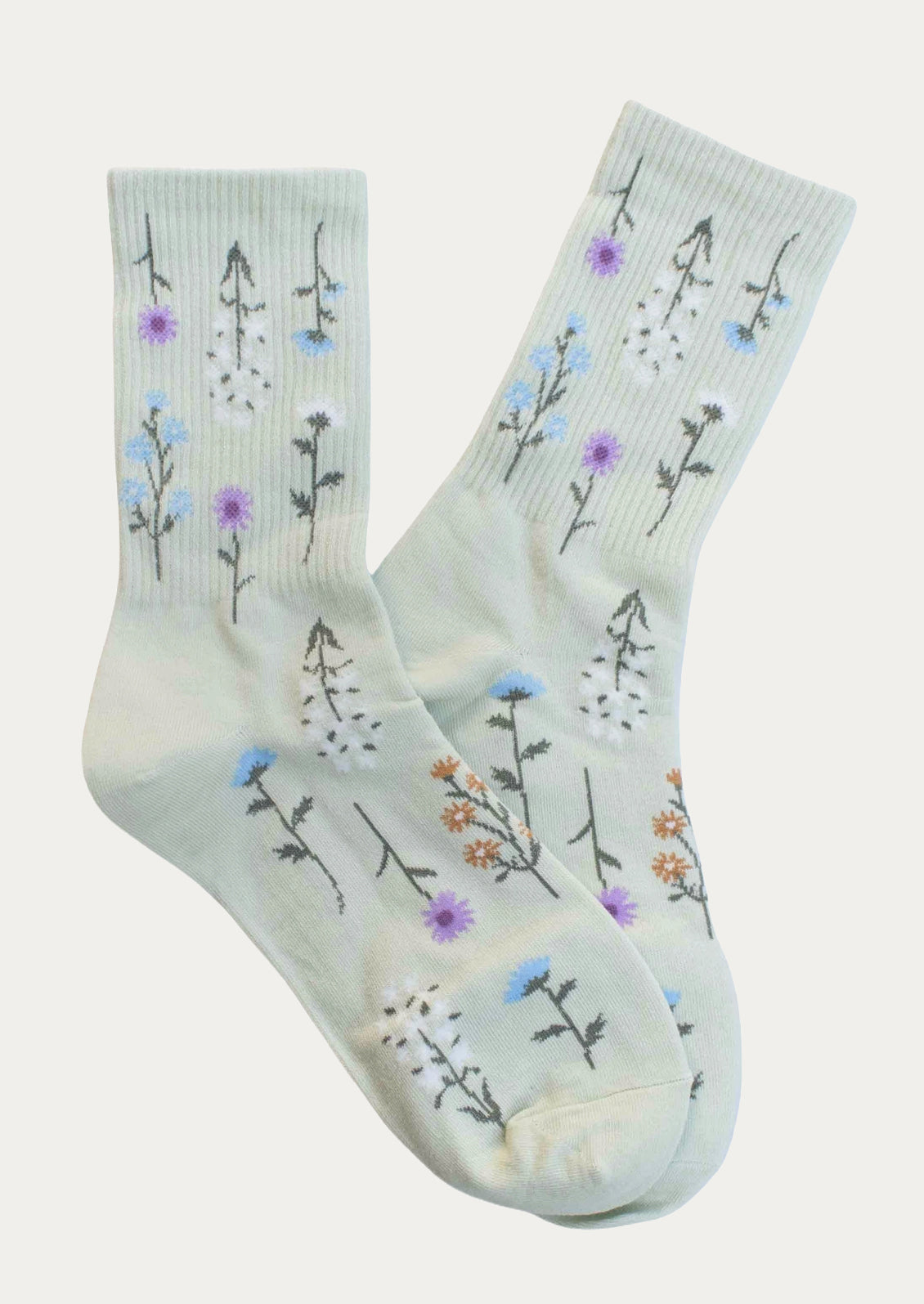 A pair of mint colored socks with blue and purple flower pattern.