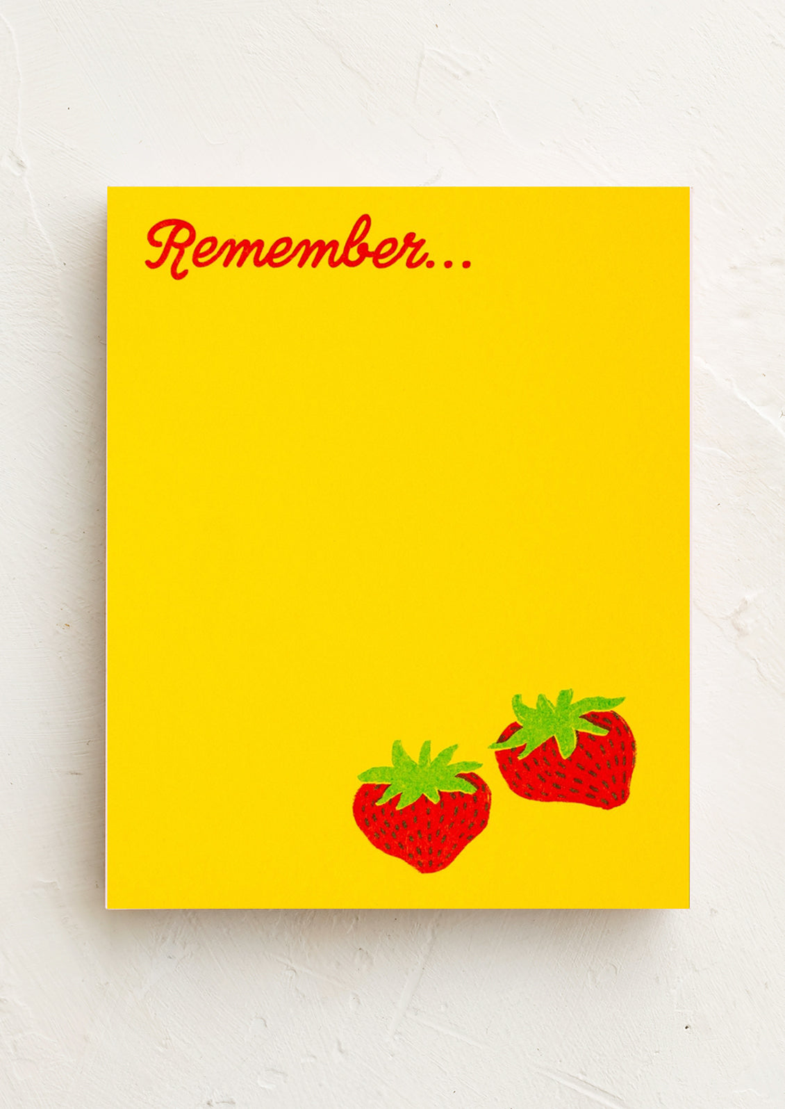 A yellow notepad with strawberry design, text reads "Remember..."