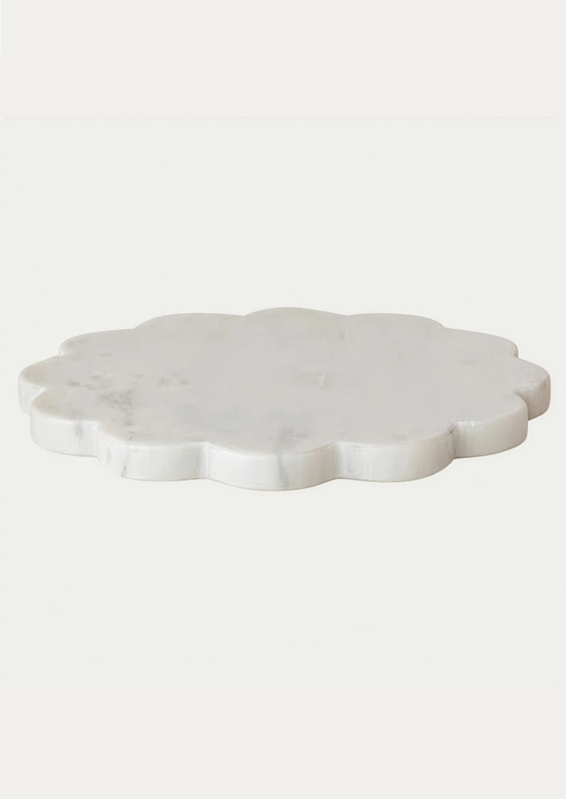 A scalloped white marble serving trivet.