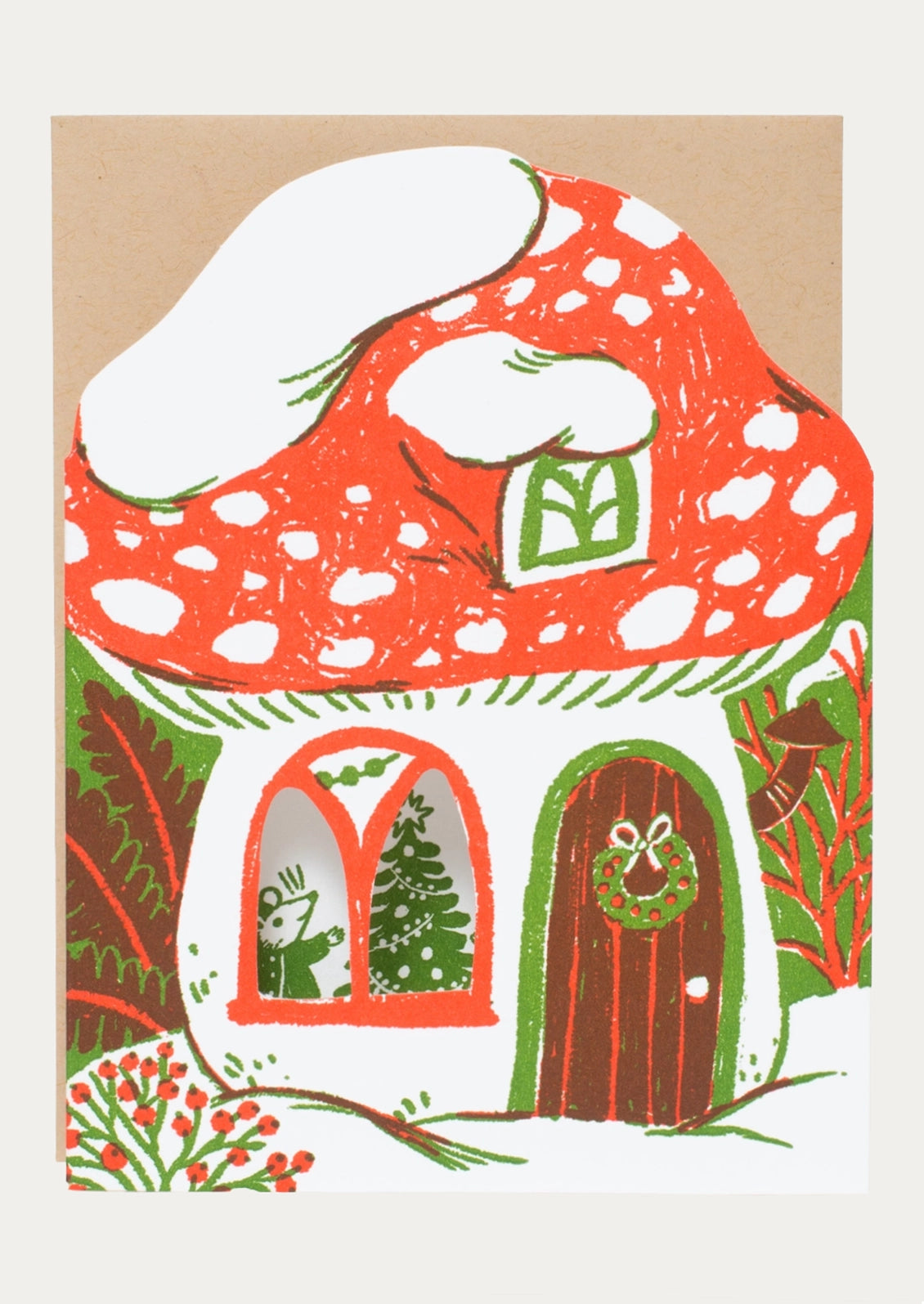 A whimsical mushroom-shaped house illustration with a red spotted cap, white snow, green trim, a brown door with a wreath, and festive windows showing a Christmas tree and figure, set on a light background.