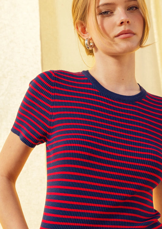 A woman wearing a short sleeve t-shirt in red and navy stripes.