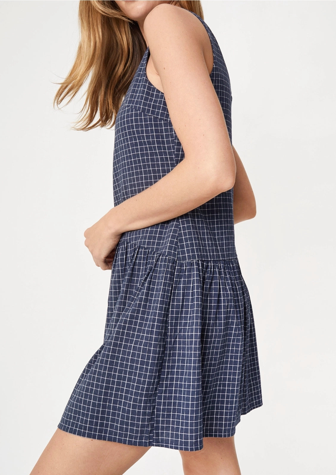 A person wearing a navy mini dress with white check pattern.