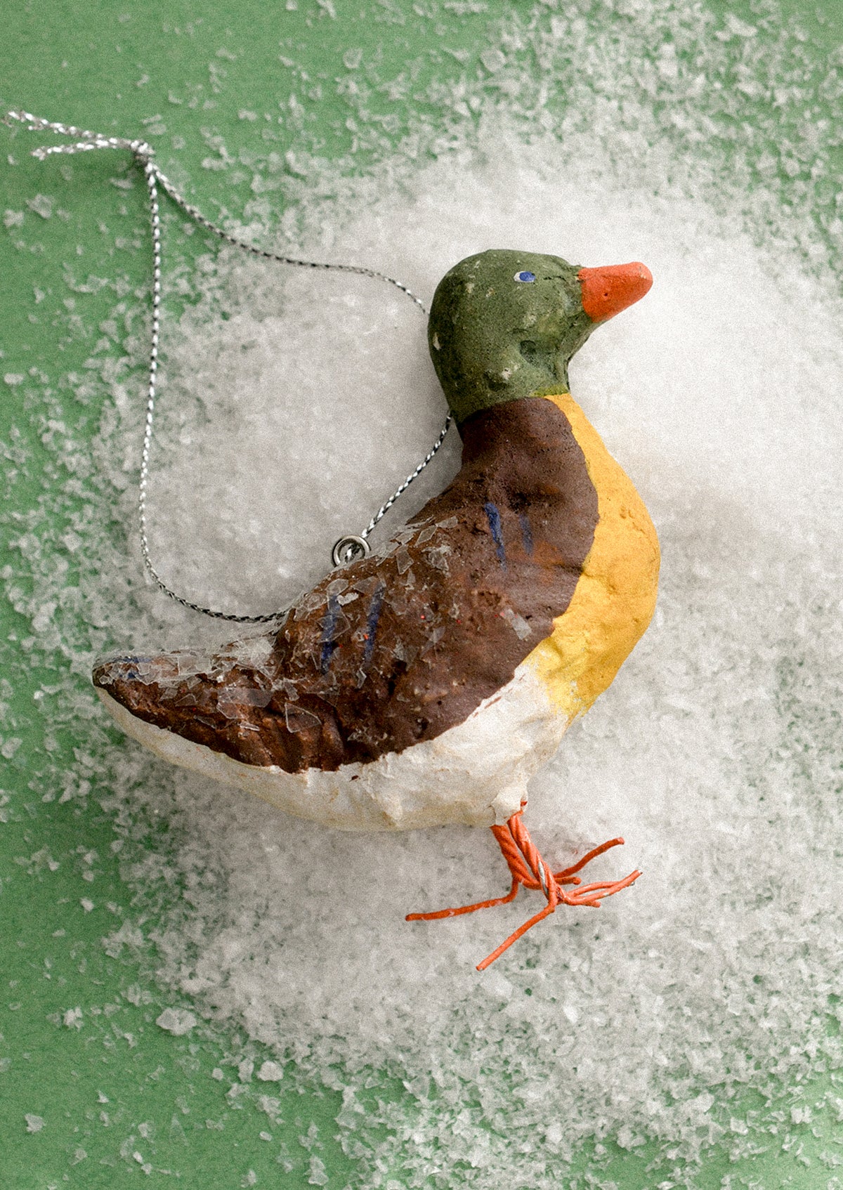 A holiday ornament made from paper mache, depicting a mallard duck.