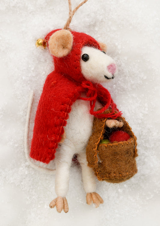 A felted wool ornament of a white mouse dressed as red riding hood, holding a basket.