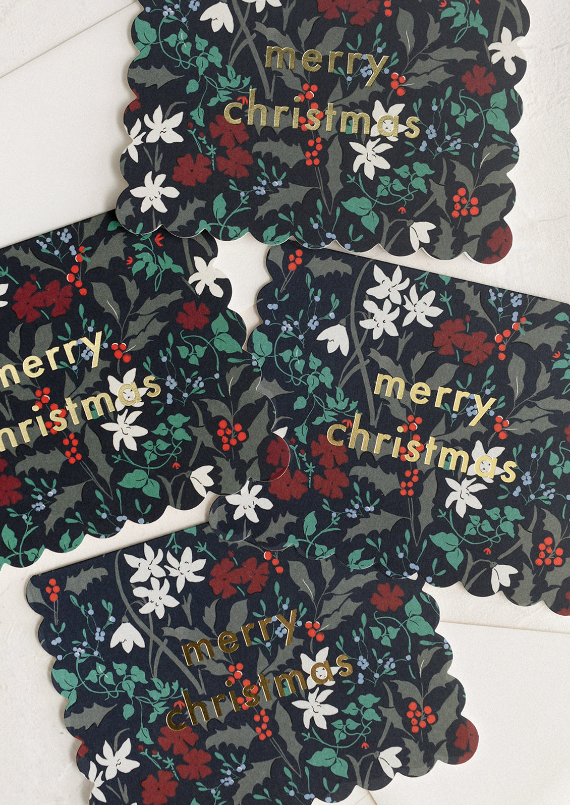 Decorative Christmas coasters with floral patterns and 'merry christmas' text on a white surface.
