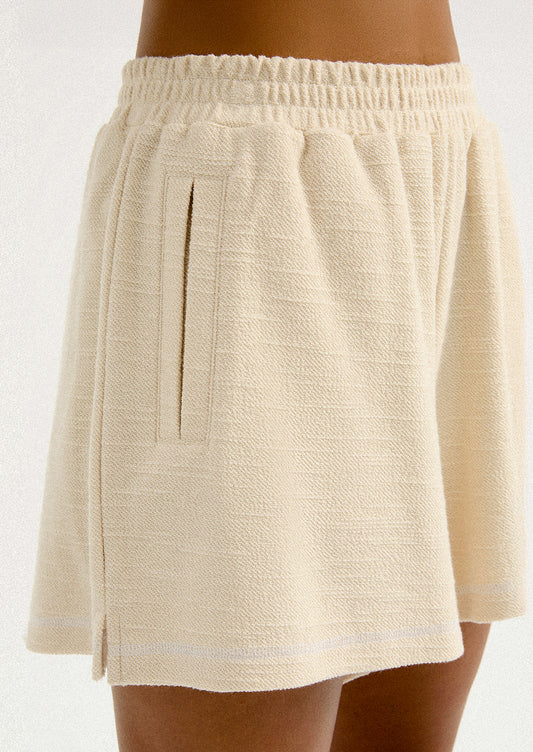 A pair of cream shorts in slub fabric with elasticized waistband.