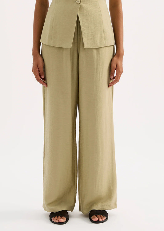 A woman wearing a pair of green suiting pants.