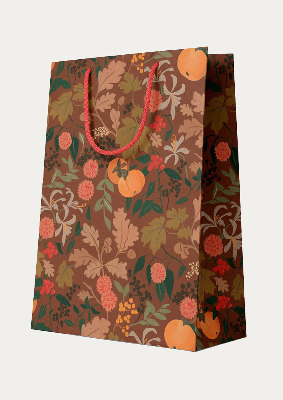 A printed gift bag in autumnal color palette with fruit and flower pattern.