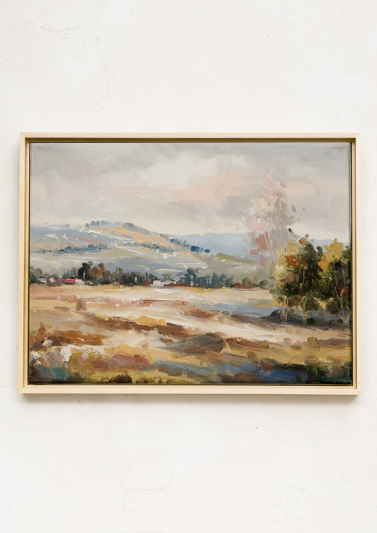 A framed landscape oil painting in muted fall tones.