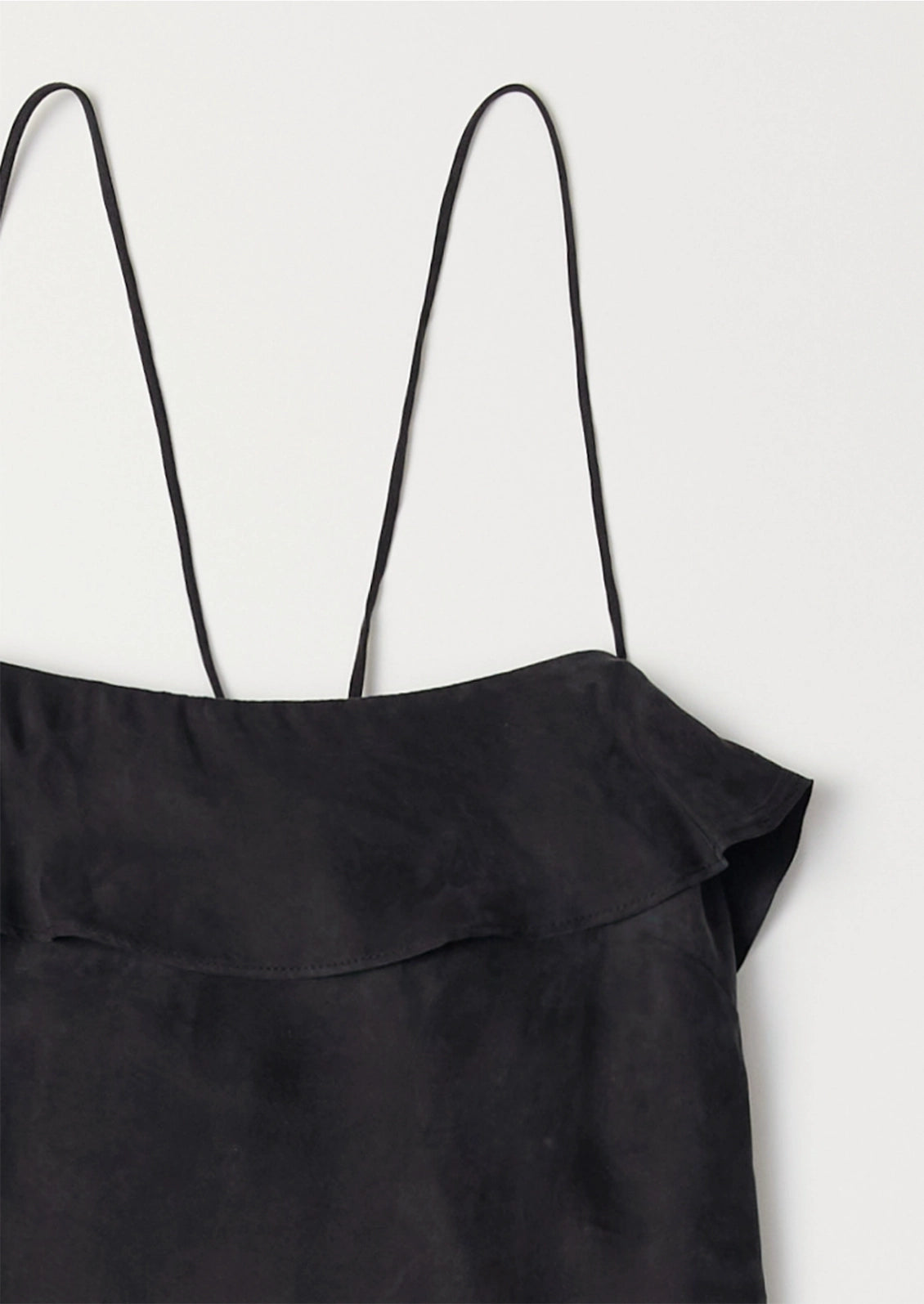 Black dress with thin straps on a light gray background