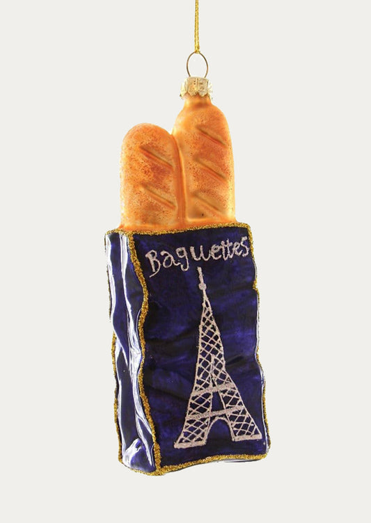 Decorative ornament shaped like baguettes in a blue bag with Eiffel Tower design on a white background