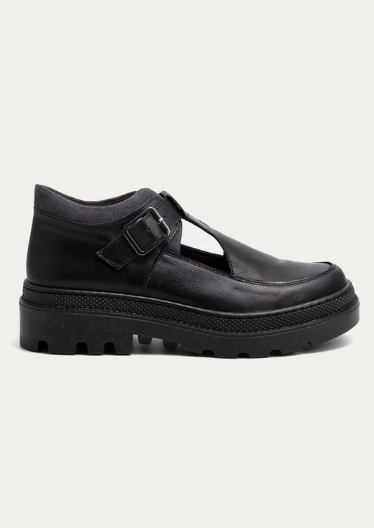 Black leather shoe with a strap and buckle on a white background