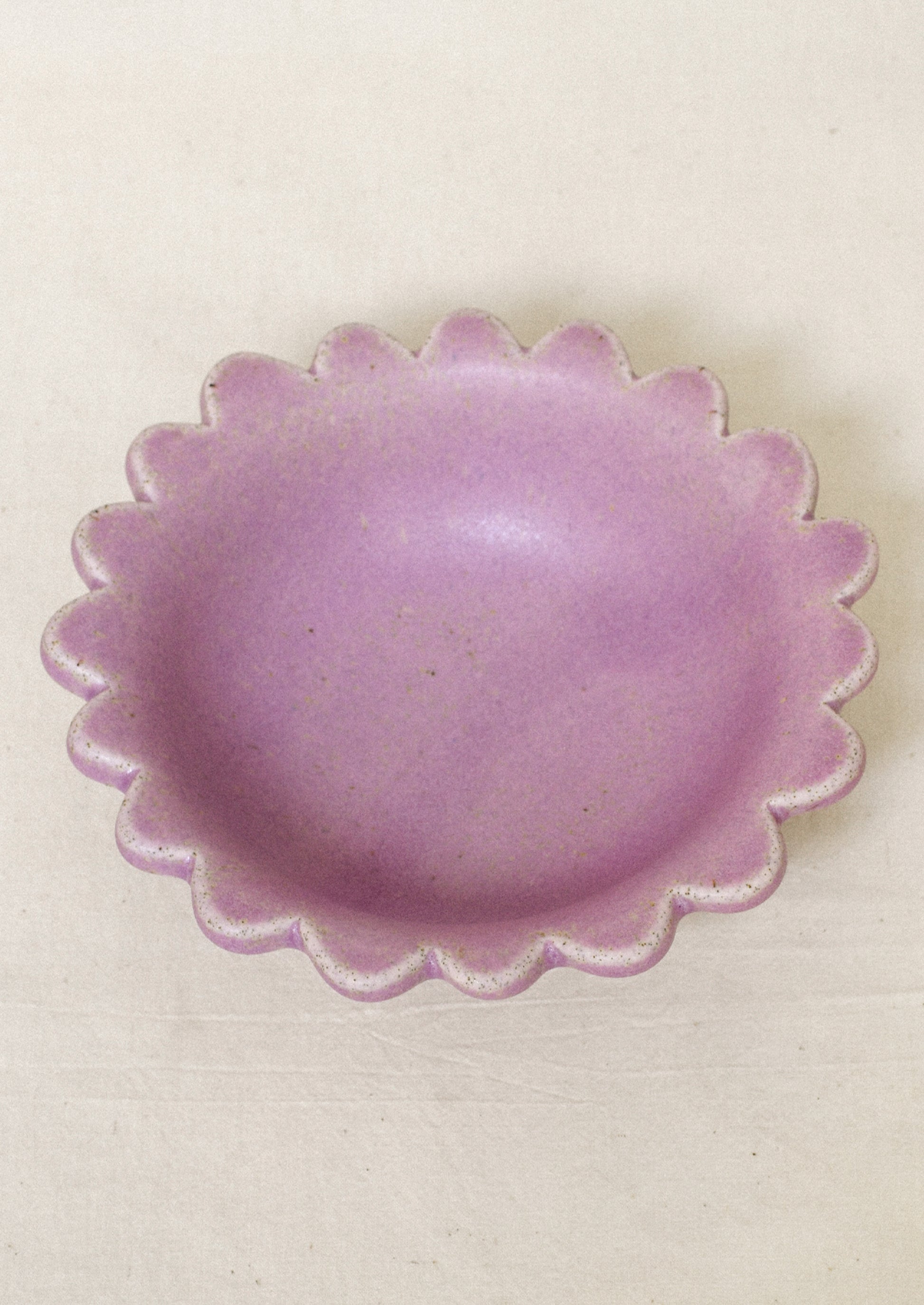 A ceramic scalloped edge bowl in a lilac color.