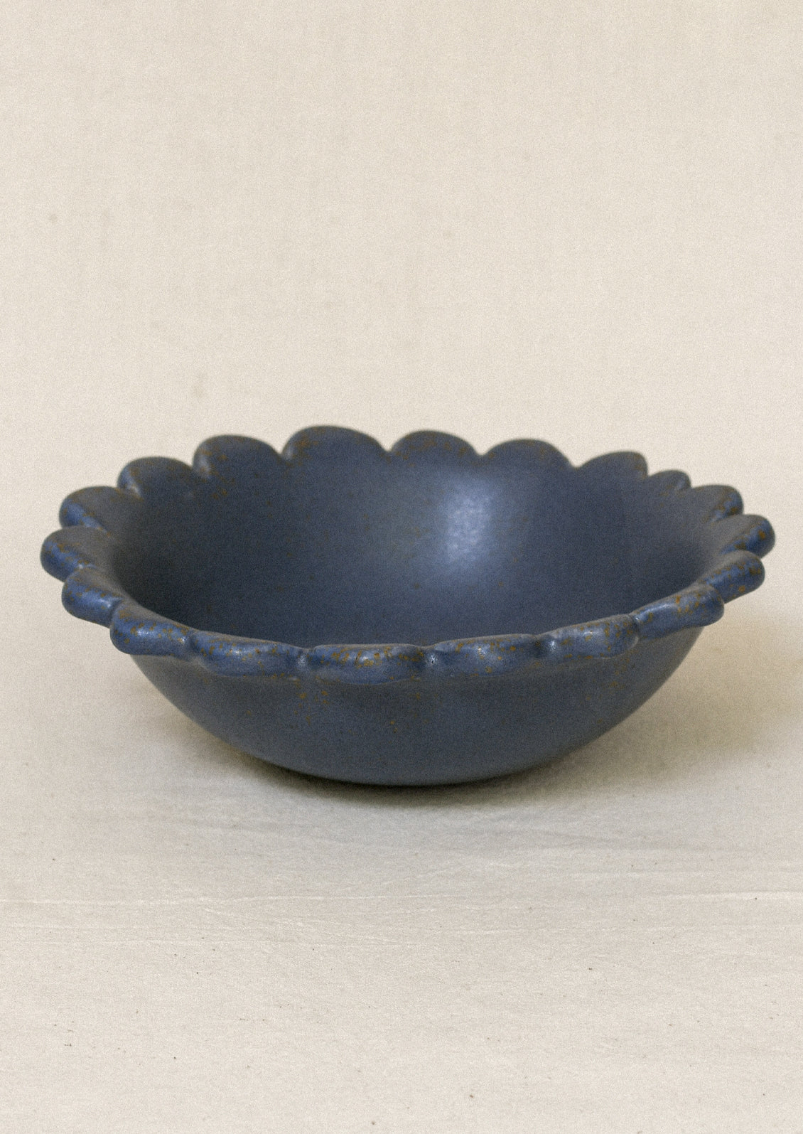 A ceramic scallop-edge bowl in a black color.