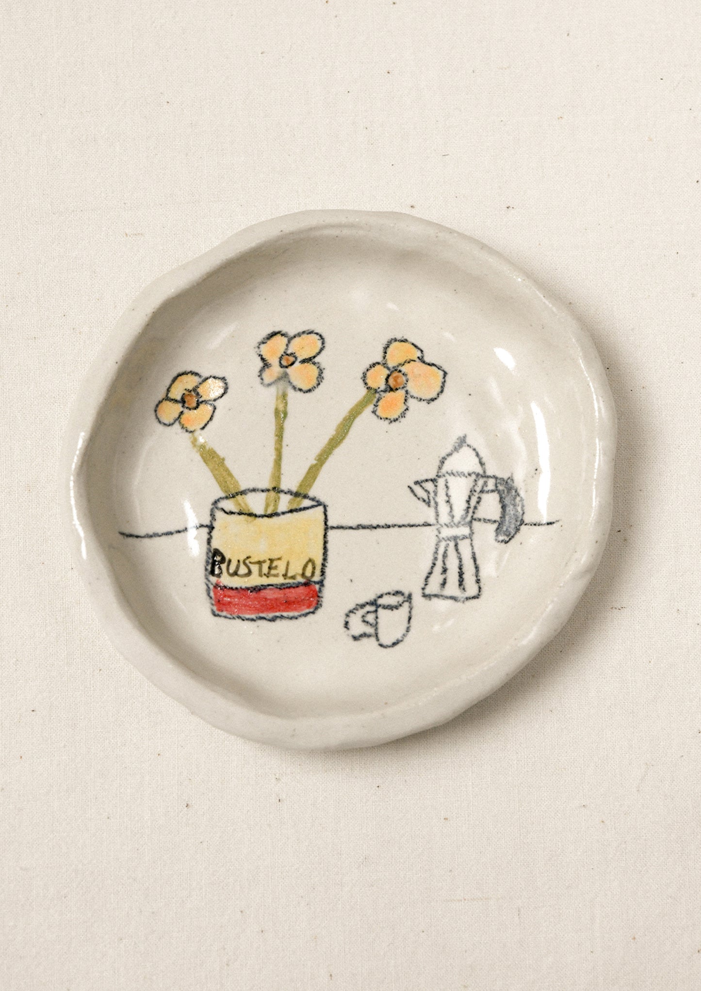 A small ceramic dish with an illustration of coffee and flowers.