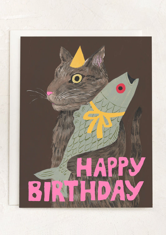 A card with illustration of cat holding fish, text reads Happy Birthday.