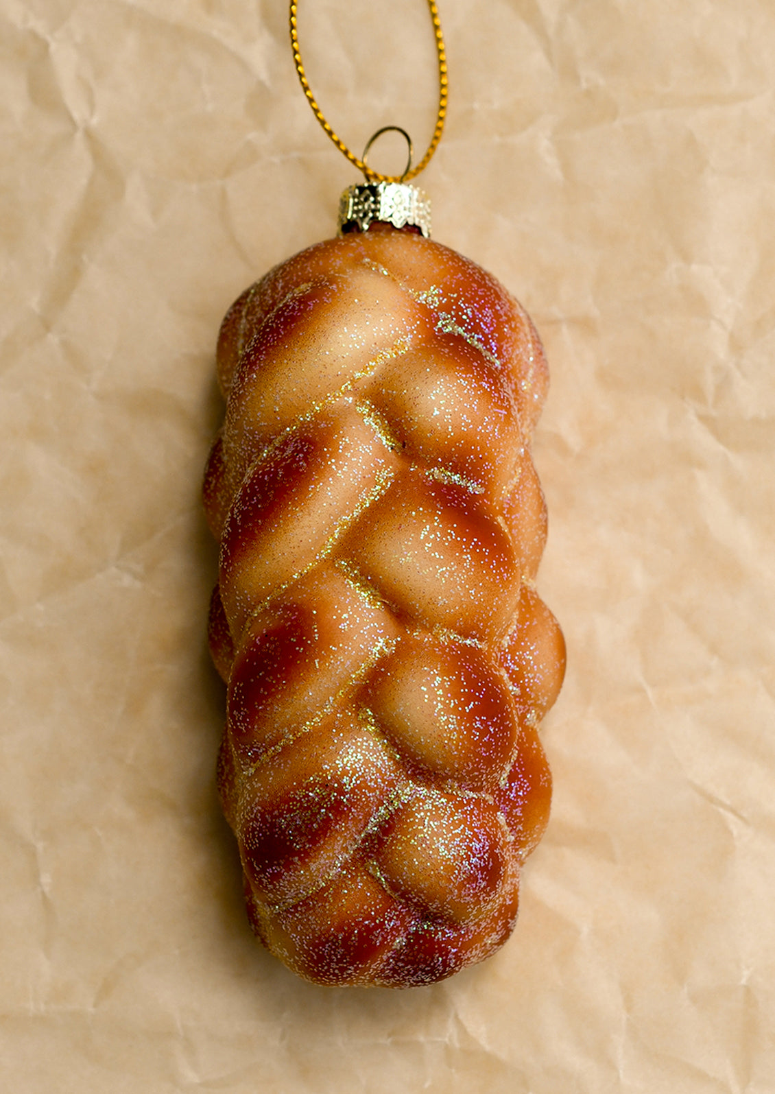 A decorative glass ornament depicting a braided loaf of challah bread.