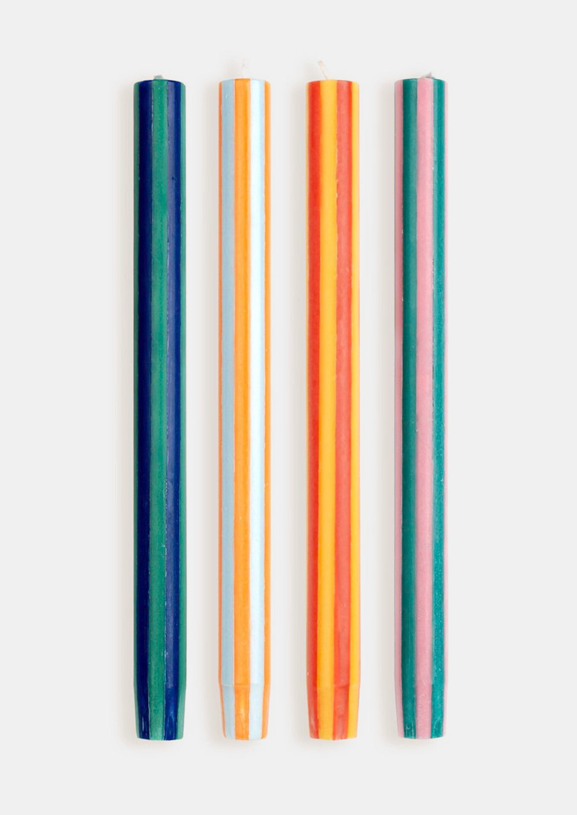 A set of striped taper candles in bright orange, yellow, pink, and green colors.
