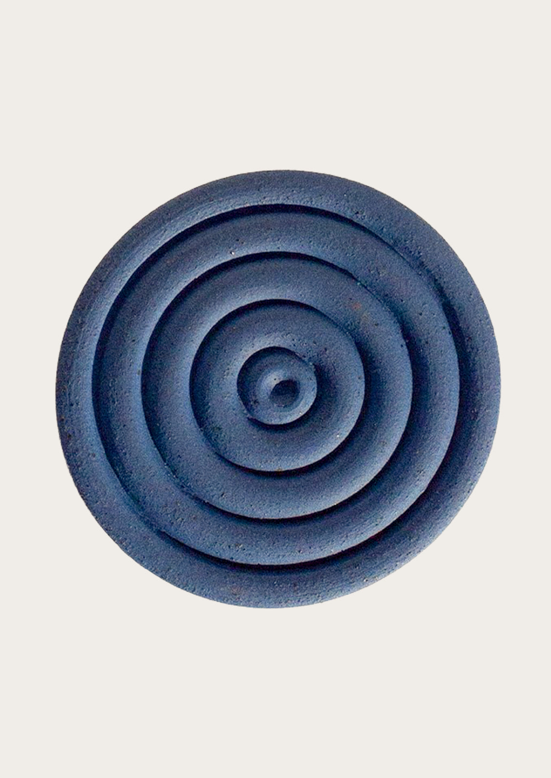 Handmade speckled ceramic coaster with a concentric design in cobalt blue.