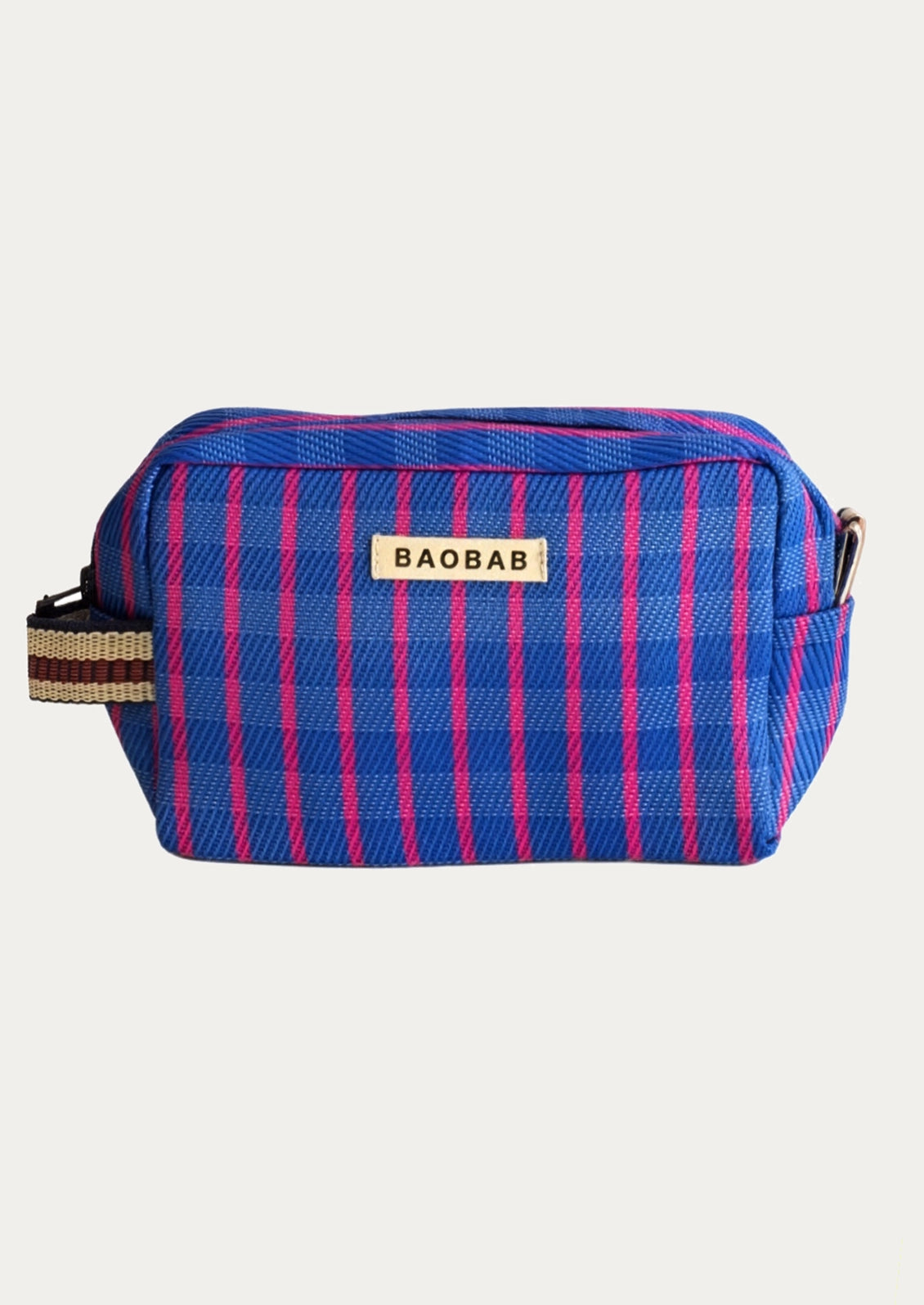 A small rectangular toiletry pouch with a blue and pink striped pattern, featuring a white label with the brand name 'BAOBAB' on the front, set against a plain light gray background.
