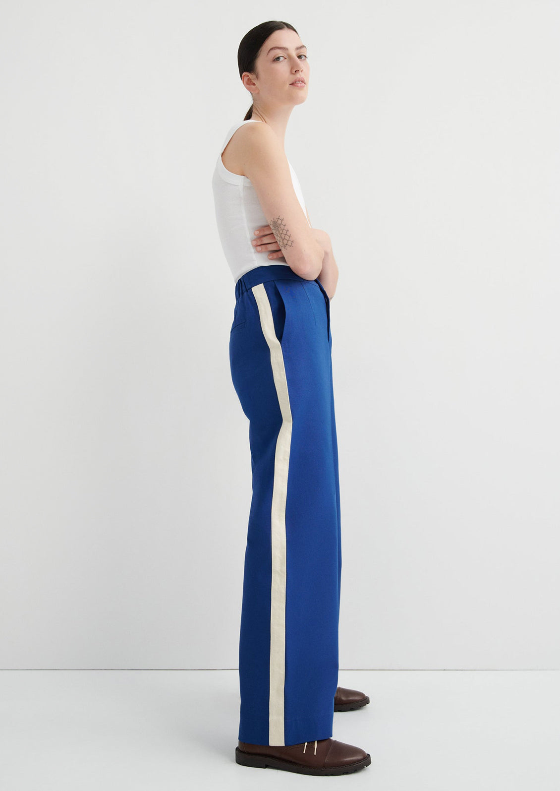 Person wearing blue pants with a white stripe on a white background