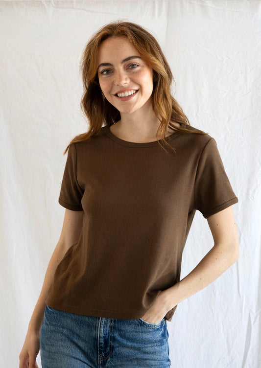 A woman wearing a pointelle stitch t-shirt in chocolate brown color.