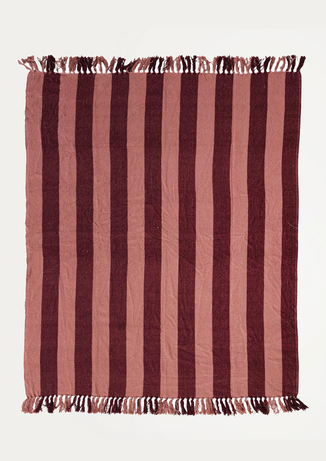 A throw blanket with vertical wine and pink stripes and fringed edges.