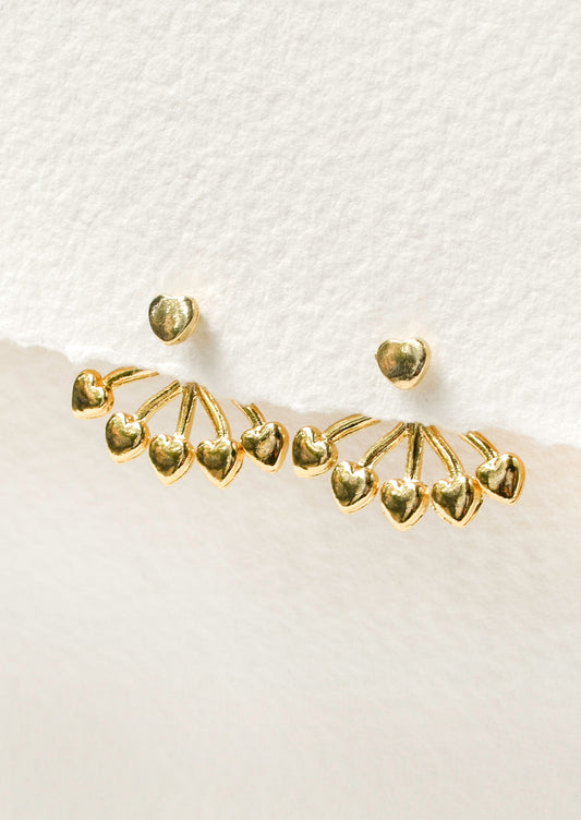 A pair of gold earrings with a heart shaped stud and five small hearts hanging below that attach on the back of the ear. 