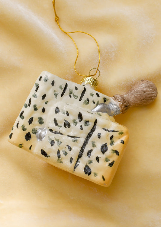 A glass ornament of a wedge of gorgonzola with cheese knife sticking out.