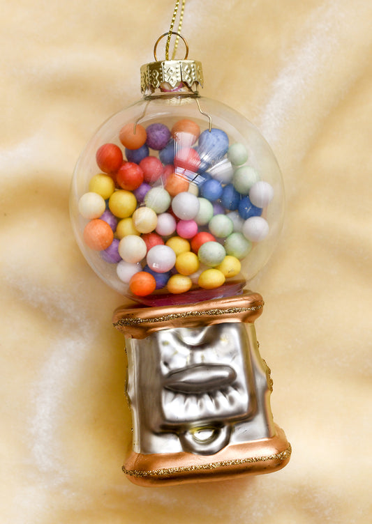 A glass ornament of a gumball machine with multicolor gumballs.
