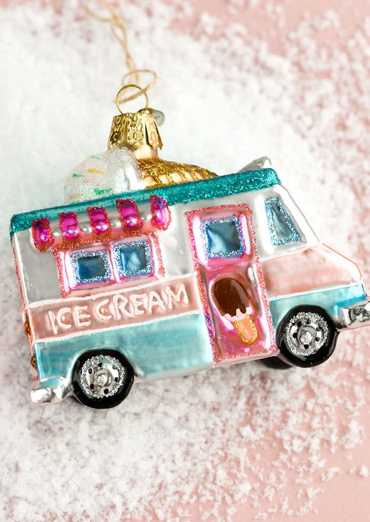 A holiday glass ornament of an ice cream truck.