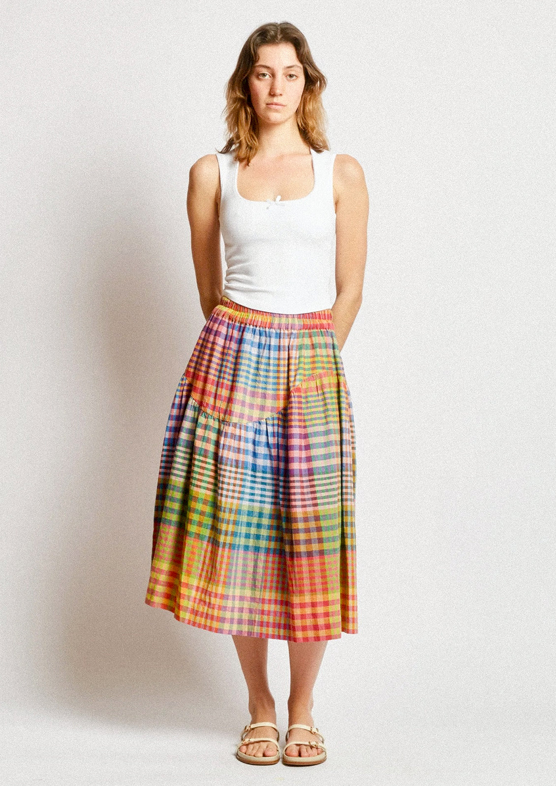 A person wearing a cotton skirt in colorful plaid.