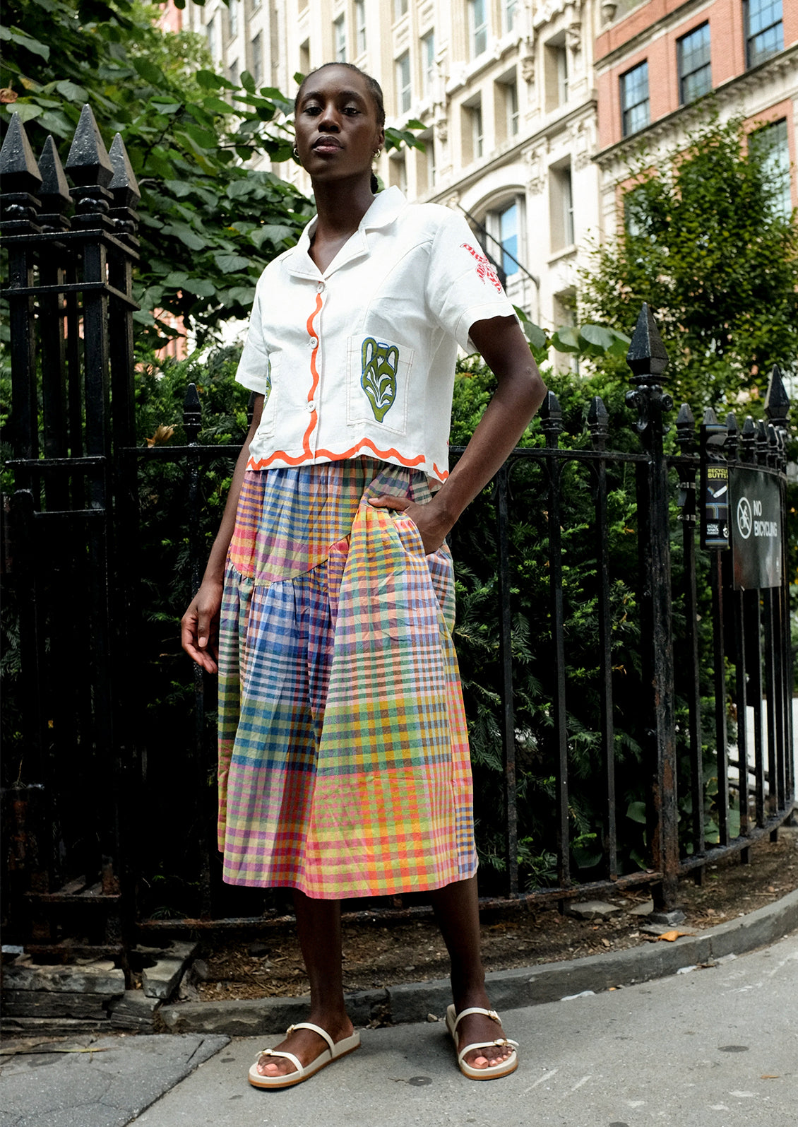 A person wearing a cotton skirt in colorful plaid.