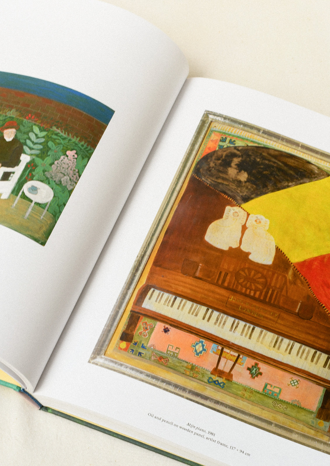An open book lying flat on a table showing two colorful pieces of art.