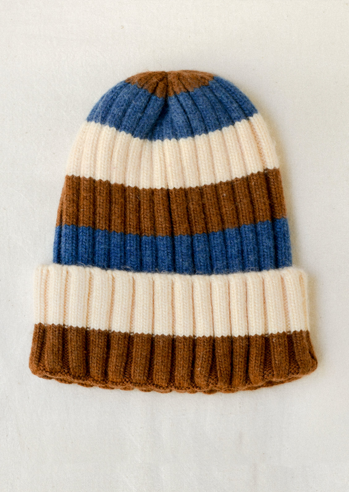 A cashmere-blend ribbed beanie with white, blue, and brown stripes.
