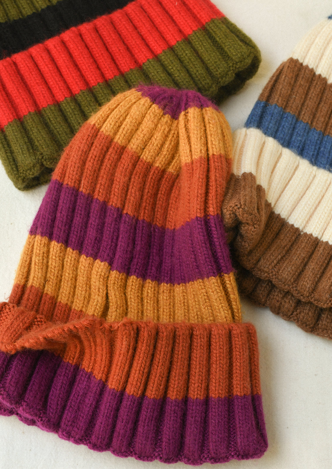 Three cashmere-blend multicolor striped ribbed beanies.