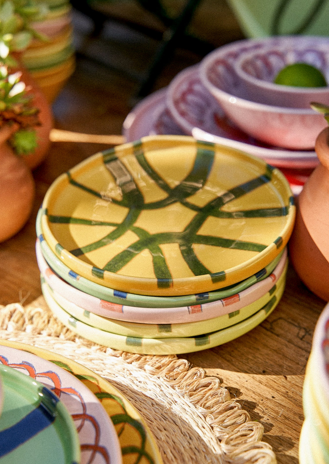 A stack of colorful ceramic plates with hand painted designs.