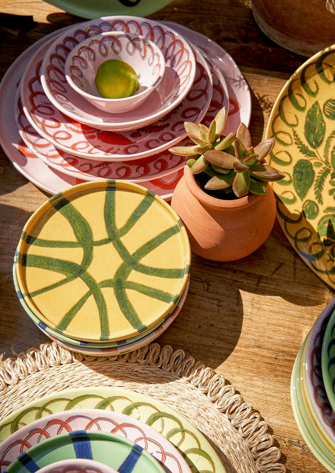 Stacks of colorful ceramic plates with hand painted designs.