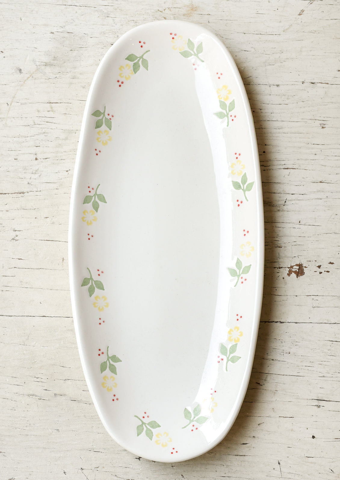 A long oval ceramic planter with yellow marigolds around the edge.