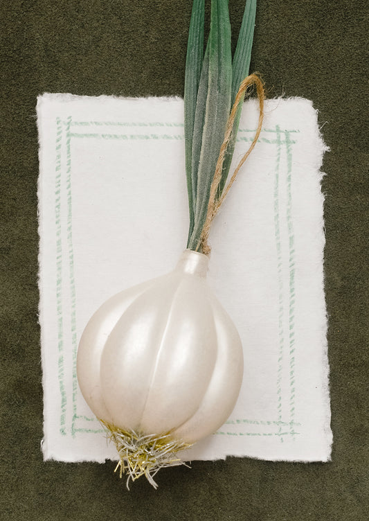 A glass ornament resembling a large white onion with stalk.