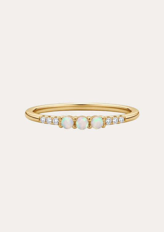 A gold ring adorned with three opals and cubic zirconia gems on either side.