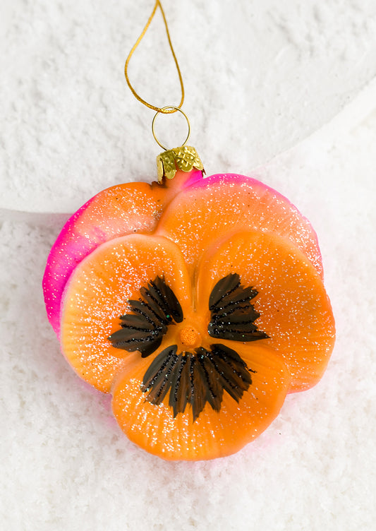 A neon pansy glass ornament.