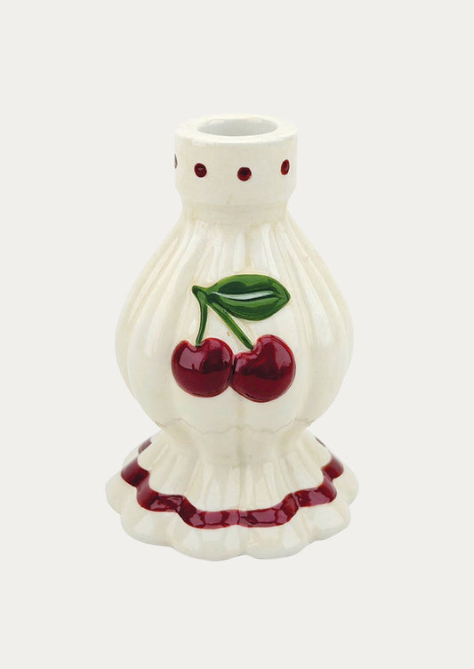 A white ceramic taper holder with a pair of red cherries on the front.