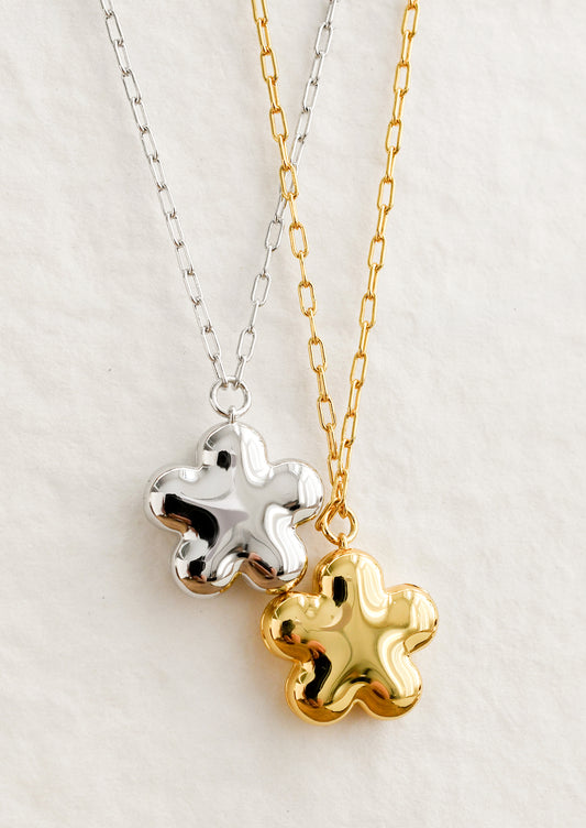 Flower shaped necklaces in gold and silver with a puffy look.