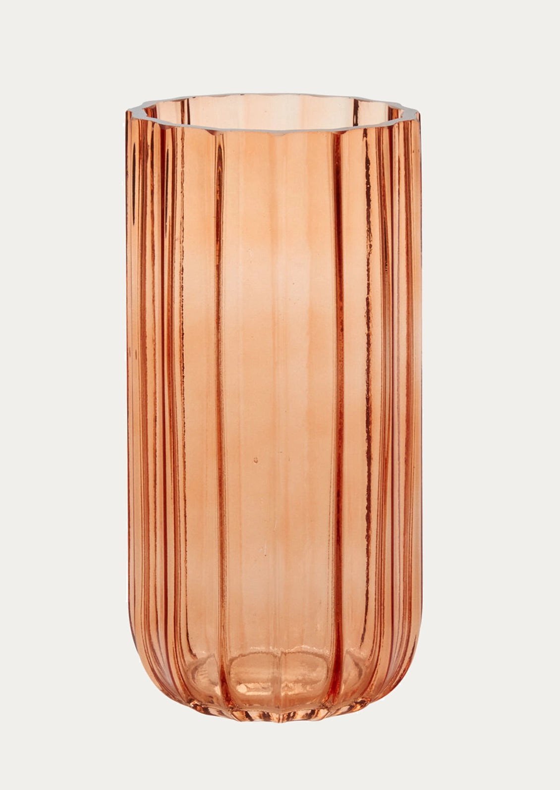 A tall, ribbed glass vase in a translucent peachy-pink color.