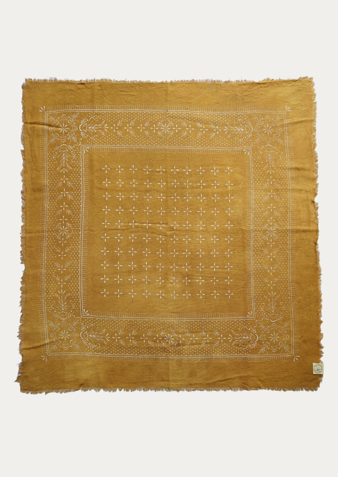 Mustard patterned scarf on a white background.
