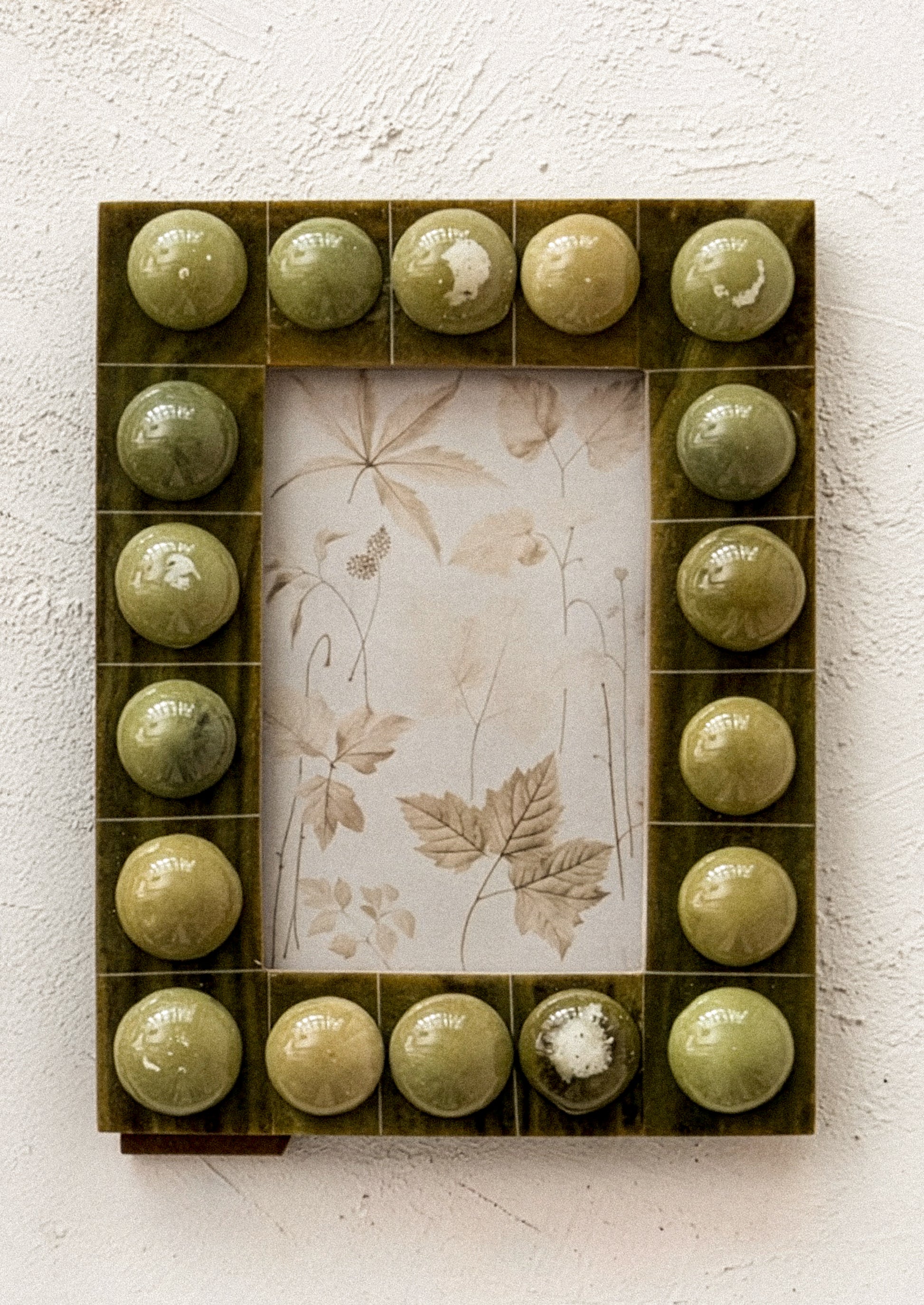 A resin picture frame with bubble hobnail border, in olive green color.