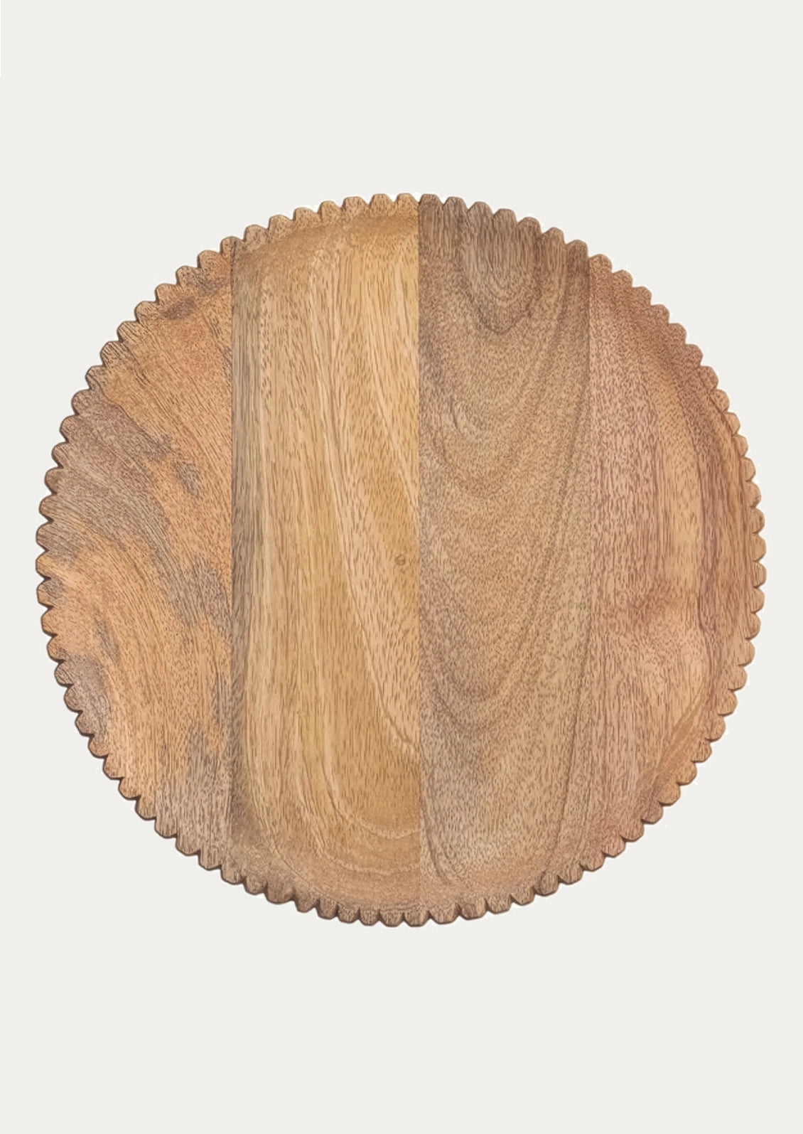 A round wooden serving board with a scalloped edge.